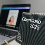 Close-up of 2025 desk calendar and laptop, ideal for office themes.
